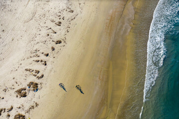 Aerial view of two men riding bicycles at the beach