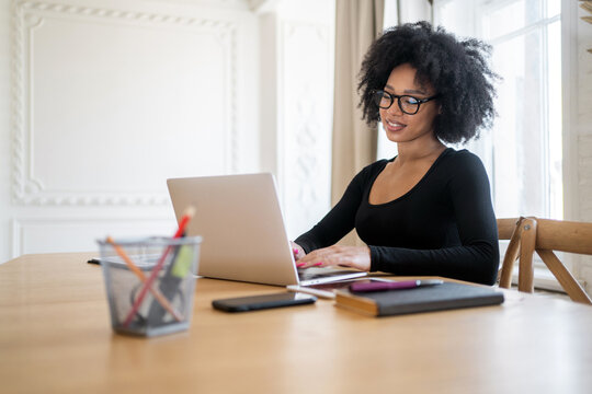 Designer female student studying online by school chat on the website, uses a laptop computer