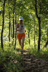 Woman runner running on forest trail.