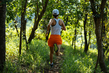 Woman runner running on forest trail.