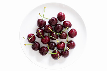 Obraz na płótnie Canvas Fresh red cherries on a saucer isolated on a white background.