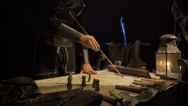 Making a battle plan by candlelight. Analyzing on the map inside the tent in the middle of the war.