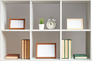 White shelves photo frames books decor. Home interior.