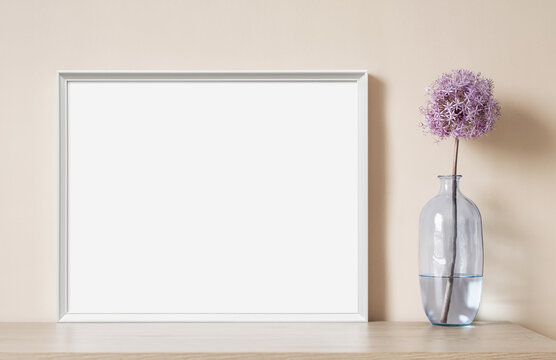 Blank picture frame mockup on beige wall. Horizontal artwork template in minimal interior design. View of modern style interior with canvas for painting or poster on wall. Minimalism concept