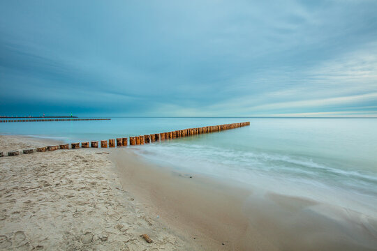 Amazing sunrise over the sea in Chalupy. seascape with breakwater