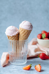 Creamy vegan strawberry ice cream in the horn in a glass on a gray background. space for text. healthy vegan dessert