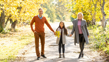 Obraz premium Family playing in autumn park having fun