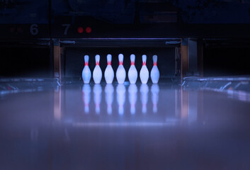 seven bowling pins with reflection on the defocus track