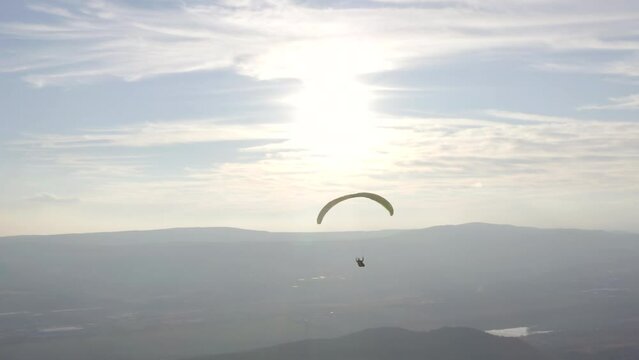 Aerial view from paragliding over the mountains flying at sunset