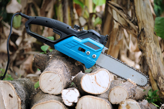 Close up of electric chainsaw laid on lumbers
