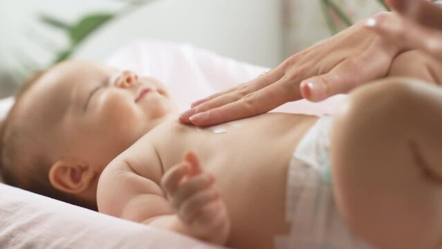 Mother applying moisturizing baby cream against dry skin. Concept of hygiene, baby care and healthcare.
