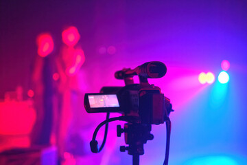 Silhouette of a TV camera, live concert, the shining stage blue light