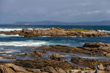 Rocky coast with birds and sea waves beating, Galicia, Spain