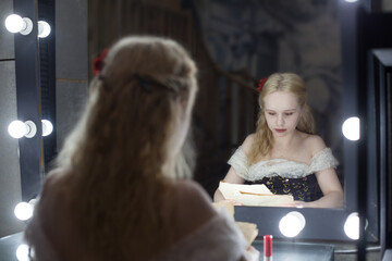 The actress or singer in the dressing room rehearses the scene sitting in front of the mirror...
