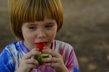 Portrait of a cute little boy eating watermelon. Close-up of the child's face. Summer mood