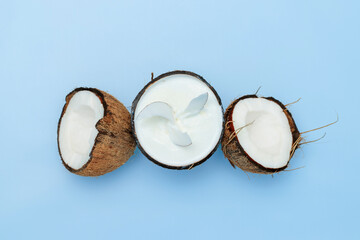Three coconut halves on a blue background, coconut ice cream, coconut and coco chips. Top view