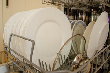 Clean dishes in the new dishwasher in the kitchen. The concept of home interior and comfort