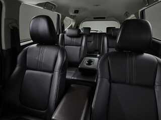 The black seats in modern cars parked outdoors in the garden show both the front and rear seats.