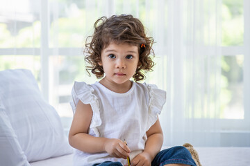 Cute young preschool Caucasian child girl sitting in living room.