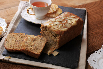 Loaf Banana Nut Sweet Bread Sliced on a Slate Plate, Served with Tea