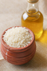  long grain rice in a bowl and bottle of oil on table 