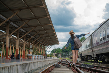 Asian woman balancing on the train rail.  Attractive young woman walking outdoors.