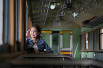 Obraz na płótnie Canvas Young asian woman traveler using smartphone in train.
