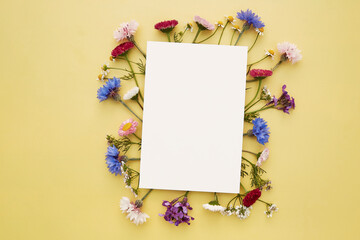 Wishing or invitation mockup stationery card. Birthday, wedding, Mothers day creative card mock up wildflowers flat lay. Place for text. Top view