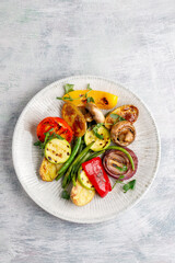 Grilled vegetables on a plate on a textured background