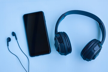 Smartphone,Black Headphone and Wired earphones on Blue background