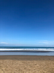Fototapeta na wymiar Sand beach in Bali with tropical sea and blue sky