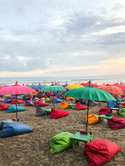 Beach sunset coastline view with colorful umbrellas in bali