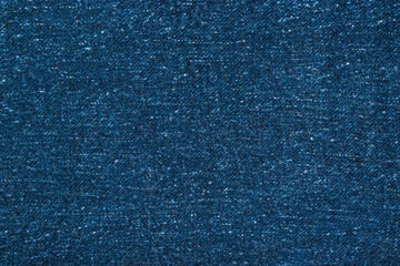 Dark blue textured denim fabric of factory production.