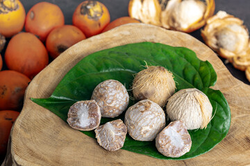 Betel nut or areca nut with betel leaf isolated on wooden background.