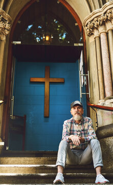 At the doorstep of faith. Shot of a senior man sitting on a church doorstep outside.
