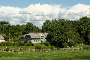 Fototapeta na wymiar Beautiful landscape with an old house across the river, Kuldiga, Latvia. High quality photo