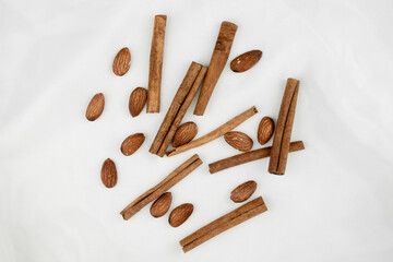 Cinnamon and almonds. Spices nuts top view on a white background. Cashews, peanuts, cassia
