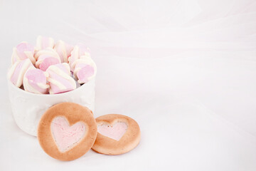 Fototapeta na wymiar Cookies and sweets on a white background. Pink lollipop heart and love. Sweets are harmful to teeth and dental treatment