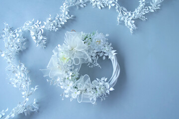 ウェディングイメージ　白い花の白いリースと白い葉のガーランド（灰色の背景）