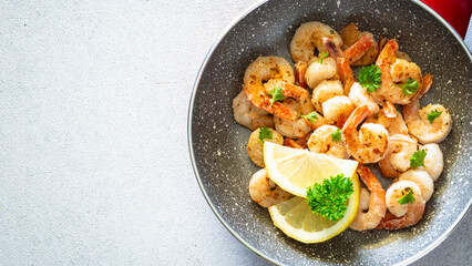 Fototapeta na wymiar Frying shrimps with lemon in the frying pan.