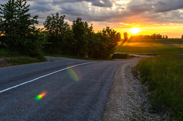 road into the sunset in a field near the village