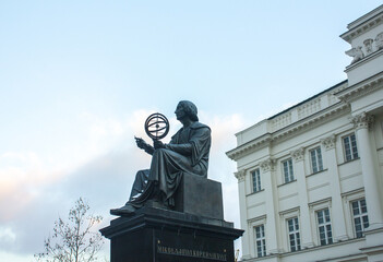 Monument to Nicholas Copernicus (1830) by Bertel Thorvaldsen holding a compass and armillary sphere in front of Academy of Science in Warsaw	
 - obrazy, fototapety, plakaty