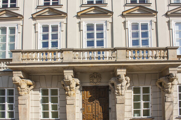 Four elegant stone Atlantes supports central balcony of historic building of Tyszkiewicz-Potocki Palace in Warsaw. Sculptures were carved in 1787 by Andre Le Brun