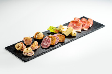 Black stone rectangular tray with snacks speck bacon salami taralli salted macaron cheese with jam