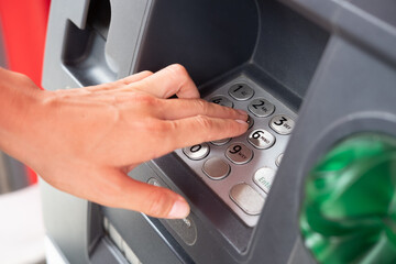 Fingers on the ATM keyboard. Set the pin code for withdrawing cash from an ATM.