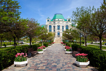 Alley with tulips in the theater park against the backdrop of the Astrakhan Opera and Ballet...