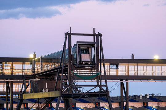 closeup of a modern cruise ship terminal with a glass passenger boarding bridge against a vivid sky during the sunset