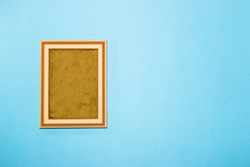 wooden frame with sand in it as copy space, creative art summer design on a pastel blue background