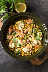 ceramic dish with baked shrimps with chickpeas on the table