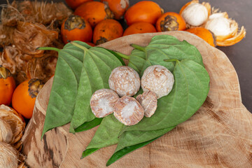 Betel nut or areca nut with betel leaf isolated on wooden background.